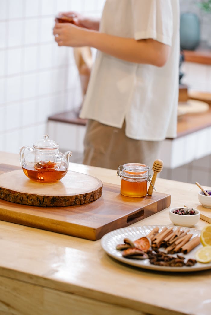 A warm setup of tea with honey, cinnamon, and lemons in a modern kitchen.